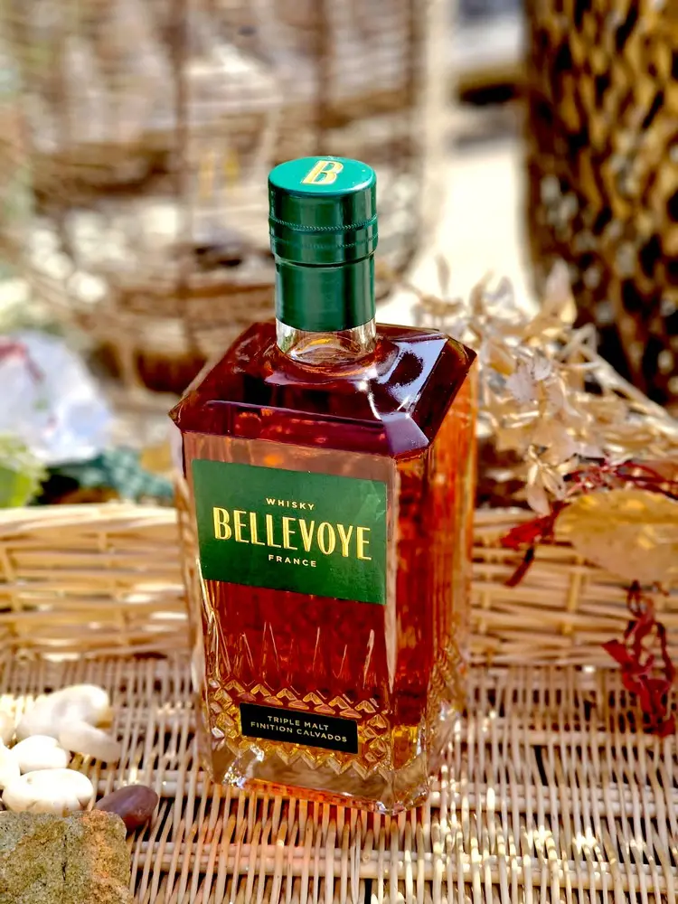 bouteille premium avec étiquette verte distinctive, triple malt français fini en fûts de Calvados