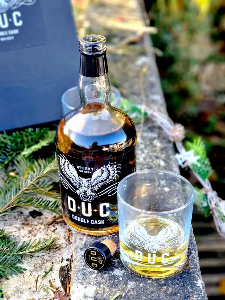 Whisky D.U.C Double Cask servi dans un verre avec reflets dorés