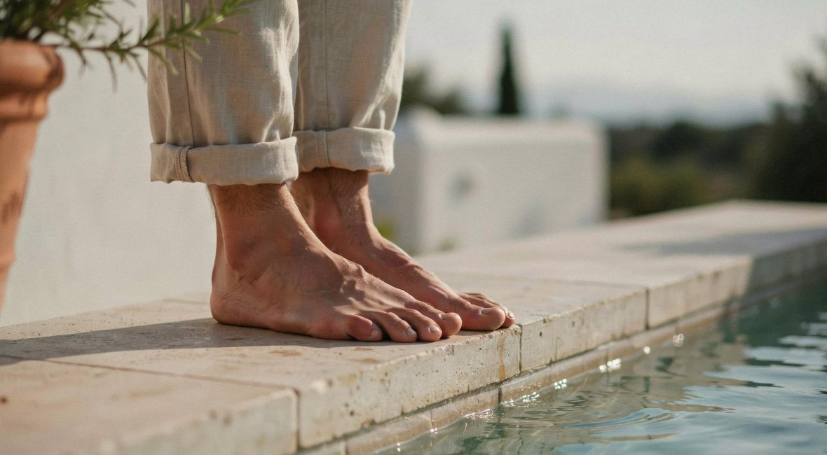 : Pieds d'homme soignés posés sur pierre, lumière méditerranéenne